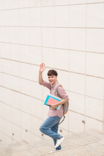 Photo smiling student with his books in university