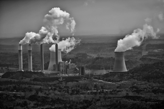 Photo smoke emitting from chimney on landscape against sky