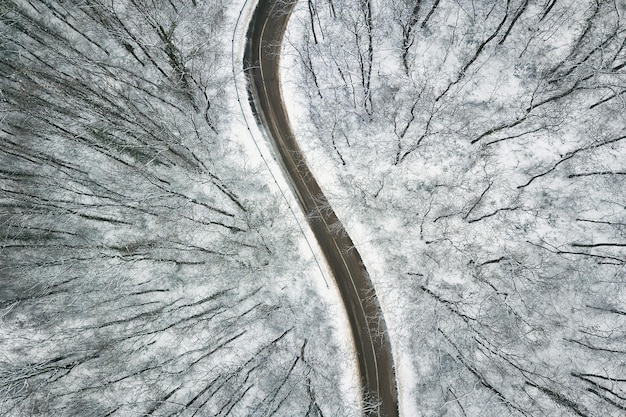 Snowy forest with a road. Aerial view.