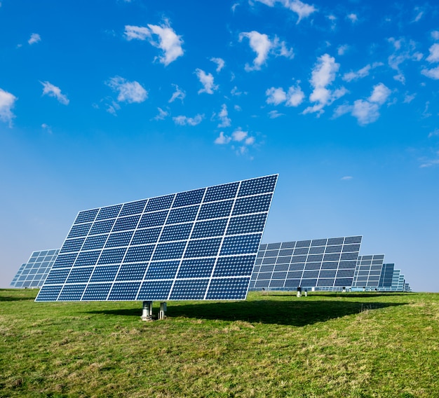 Photo solar panels on green field and blue sky