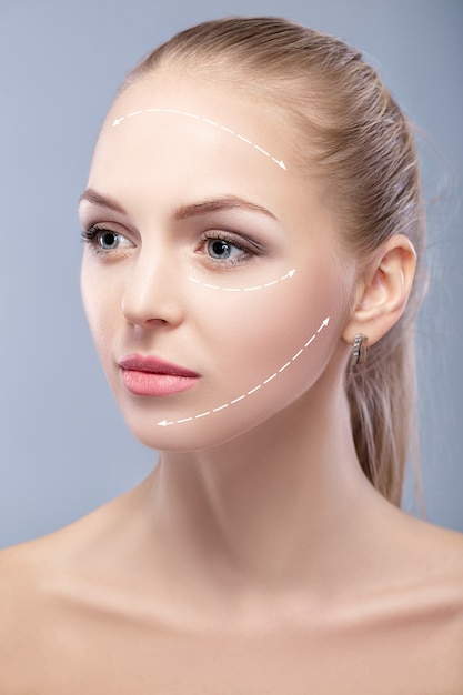 Spa portrait of attractive woman with arrows on face face lifting concept plastic surgery treatment ...