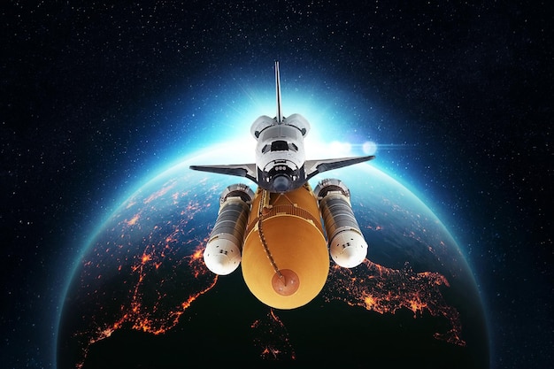 Space shuttle rocket successfully flies against the background of the beautiful blue planet Earth with the amazing sunset Creative Space Wallpaper and Technology Concept Spaceship
