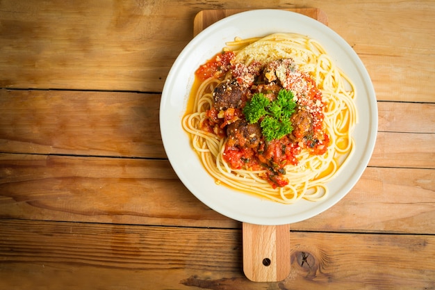 Photo spaghetti and meatballs on the wood board.