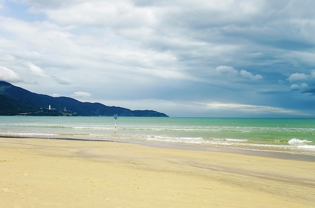 Photo splashes of water in the sea at the china beach in danang in vietnam. it is also called non nuoc beach. south china sea and marble mountains on the background.