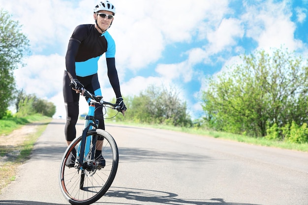 Sporty cyclist riding bicycle outdoors on sunny day