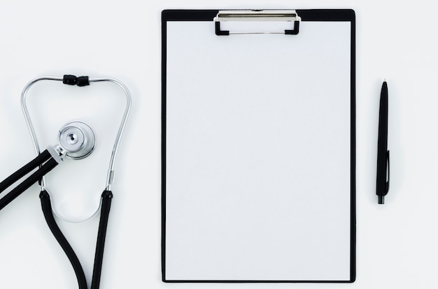 Stethoscope; white paper on clipboard with pen isolated on white backdrop