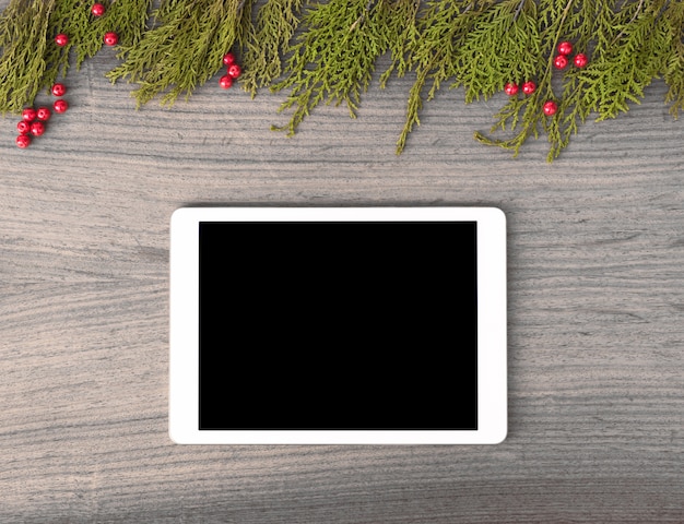 Photo tablet display on table with isolated white screen for mockup in christmas time