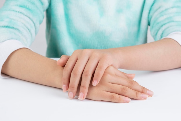 Teenager hands referring to hand care on a table