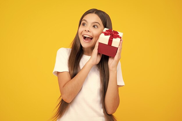 Photo teenager kid with present box teen girl giving birthday gift present greeting and gifting concept excited teenager glad amazed and overjoyed emotions