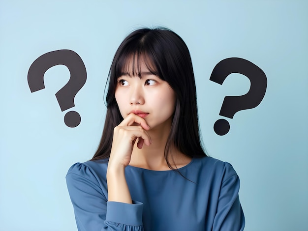 Photo thoughtful woman surrounded by question marks on a blue background