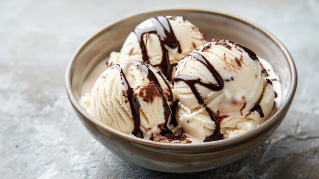 Photo three scoops of ice cream in a bowl topped with a drizzle of chocolate