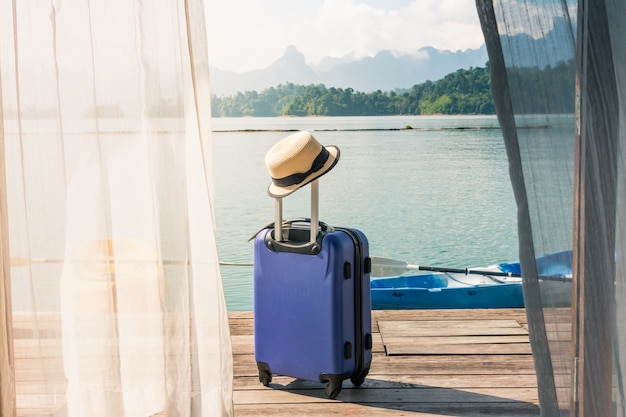 Photo time to relax, suitcase standing on the floor with cap out the room, travel lifestyle.