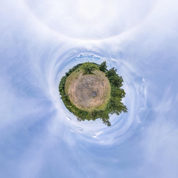 Tiny planet in blue sky with sun and beautiful clouds Transformation of spherical panorama 360 degrees Spherical abstract aerial view Curvature of space