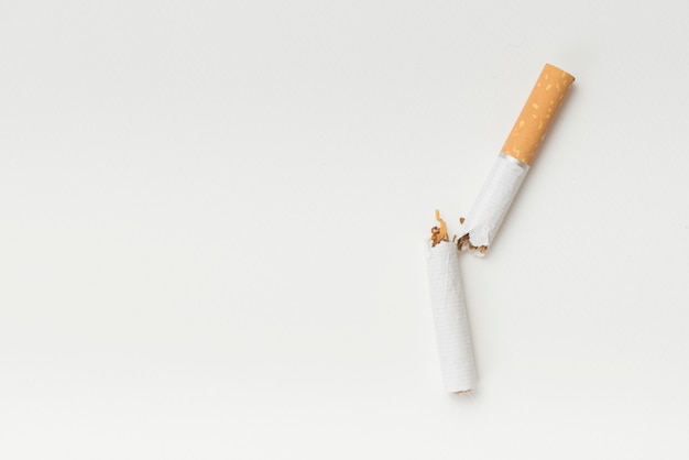 Top view of broken cigarette on white background