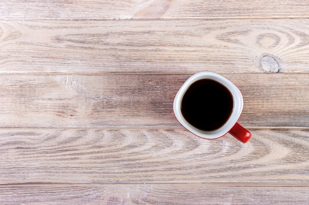 Top view of coffee in red cup on wooden vintage table