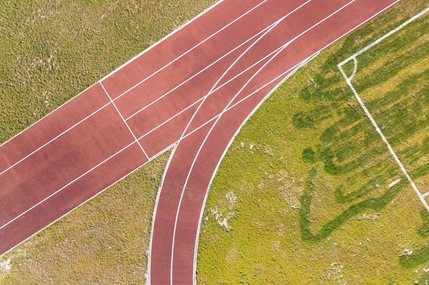 Photo top view of red running tracks and green grass lawn. infrastructure for sports activities.