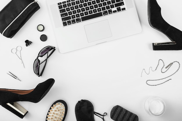 Top view of workplace with laptop and women accessories