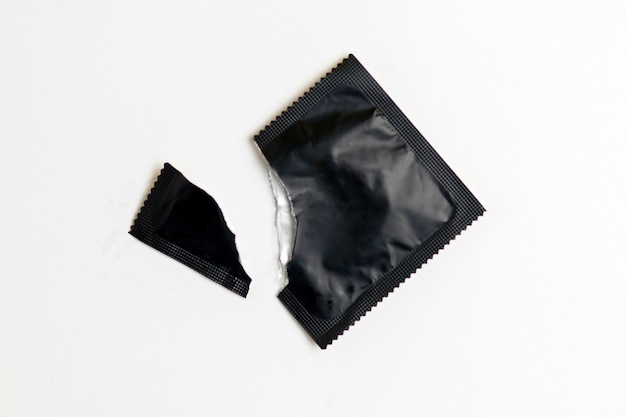 Photo torn pack of condom on white background safe sex concept