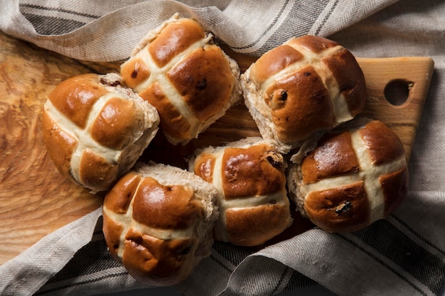 Traditional hot cross buns with raisins on a wooden board