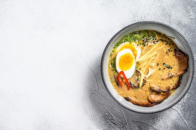 Foto tradizionale zuppa di ramen giapponese con brodo di carne, spaghetti asiatici, alghe, fette di maiale, uova. sfondo bianco