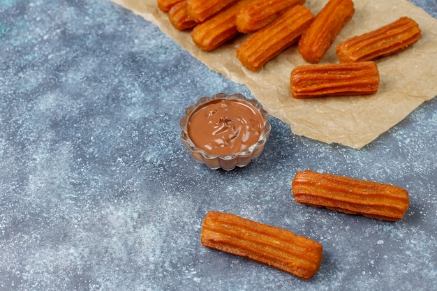 Traditional Mexican dessert churros with chocolate, top view