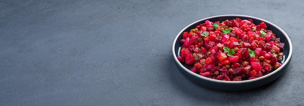 Traditional salad vinaigrette with beetroot vegetables and peas on a graphite background