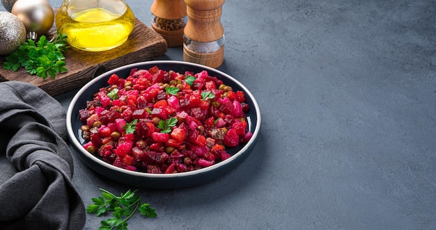 Traditional salad vinaigrette with vegetables peas and sauerkraut on a dark background