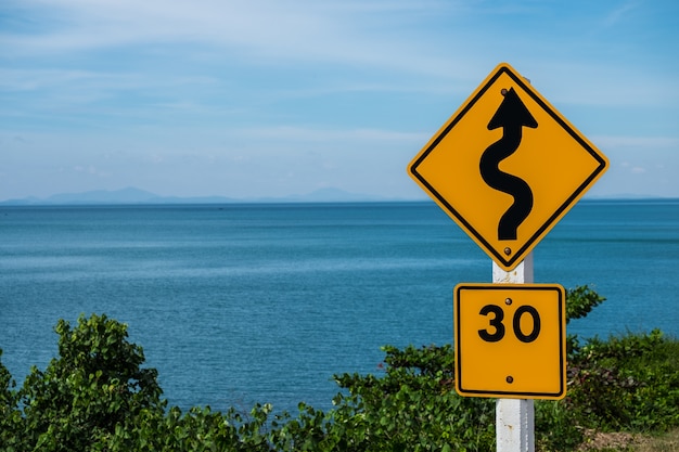 Traffic sign indicating a winding road limiting speed to 30 kilometers per hour.