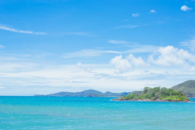 Photo tropical island and boat. green island in the blue sea on a cloudy sky