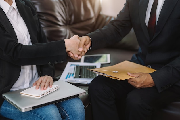 Two confident business man shaking hands during a meeting in the office success dealing greeting and partner in sun lightxA