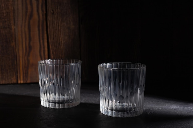 Two empty glasses in a dark studio environment