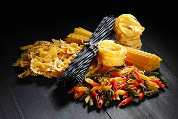 Variety of types and shapes of Italian pasta on black table