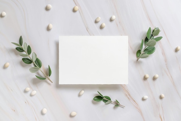 Vertical card on a marble table decorated with eucalyptus branches top view Wedding mockup