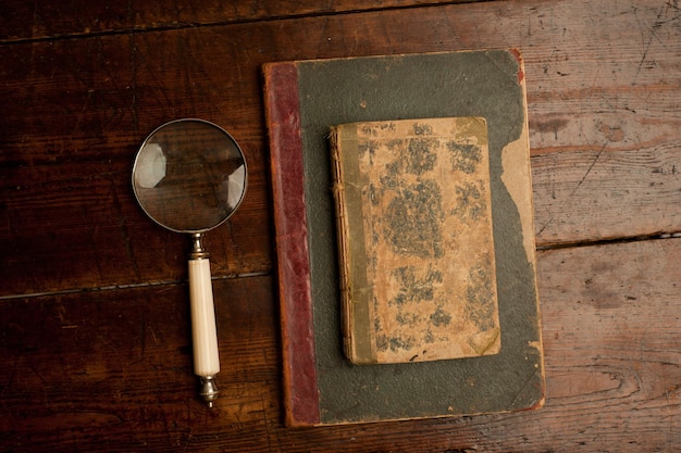 vintage book with optical magnifying glass on old wooden table