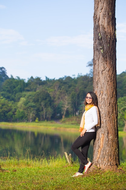 Vrouw die zich tegen de boom bevindt