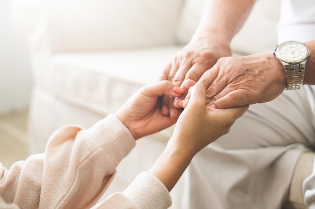 Foto vrouwenhand die oude hogere oudere hand met liefde en zorg houden