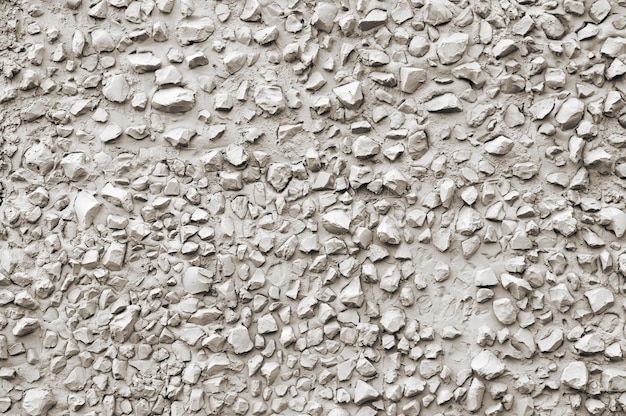 A wall of cement with a lot of small stones.