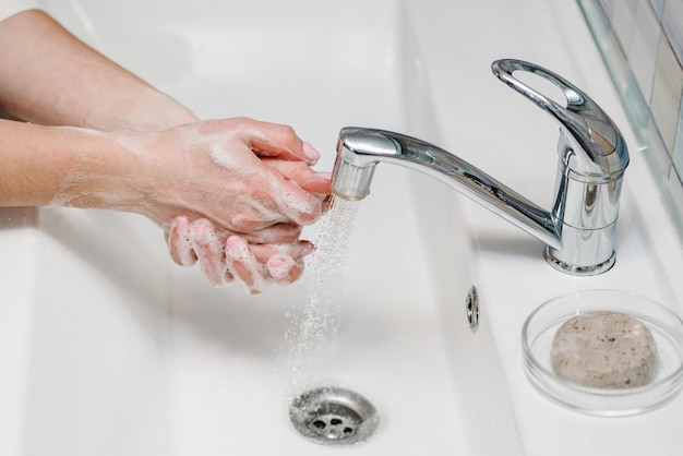 Washing hands. Coronavirus prevention. Wash hands with antibacterial soap, warm running water rubbing nails and fingers in sink. Epidemic Covid-19. Prevention of flu disease.