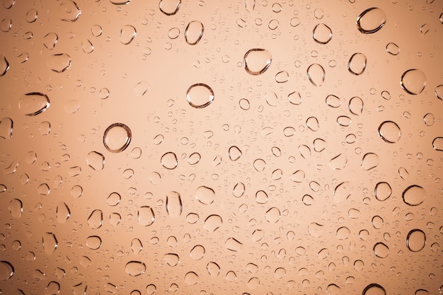 Water drops on Brown glass background.