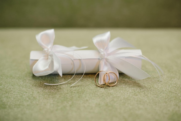 Wedding invitation with a straw with white bows and wedding rings