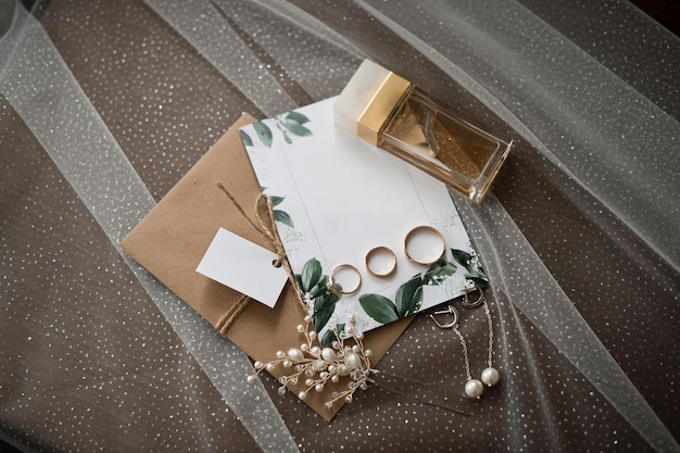 Wedding jewelry perfumes and envelopes with invitations on the table