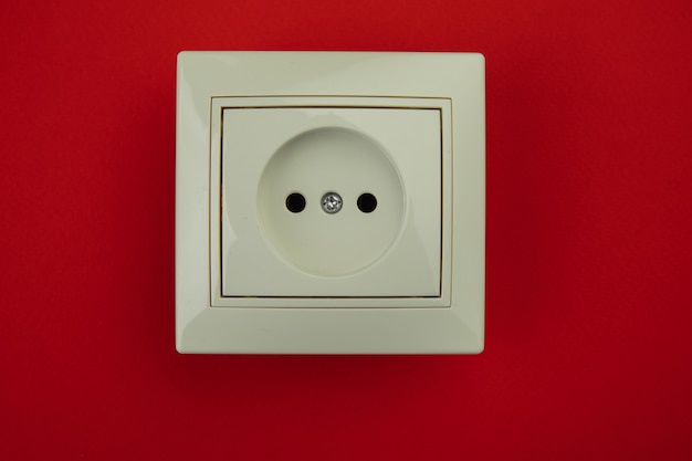 White electrical socket isolated on red background