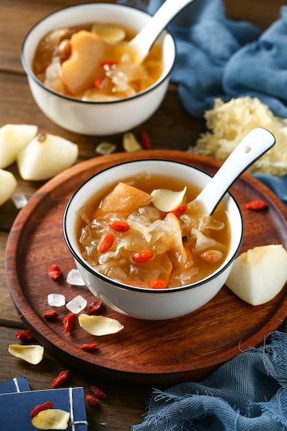 White fungus soup and pear in white bowl on wooden plate