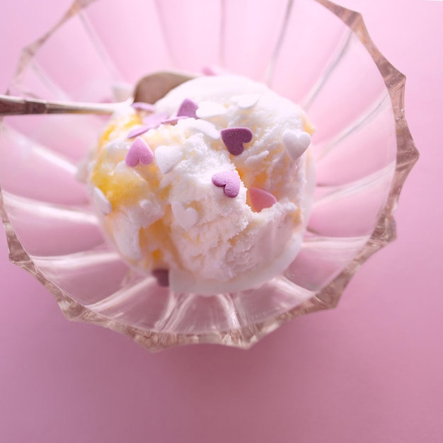 Photo white natural vegetarian sorbet ice cream with sweet hearts on it with small spoon in vase