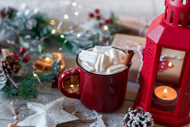 Winter hot drink, cacao with marshmallows and cinnamon or spicy hot chocolate in red cup.