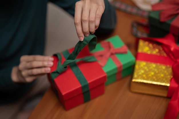 Woman hand wrapping gift box on table for christmas