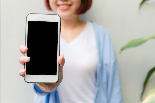 Woman hands using smart phone with blank screen background for mock up