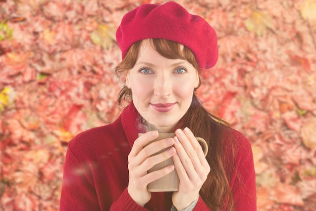 Woman holding a warm cup against peaceful autumn scene in forest