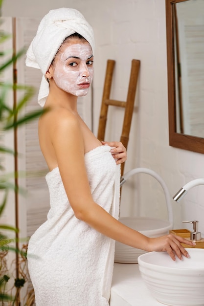 Woman is applying mask on her face