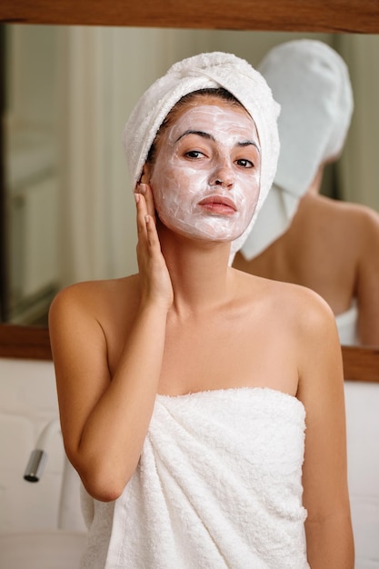 Woman is applying mask on her face